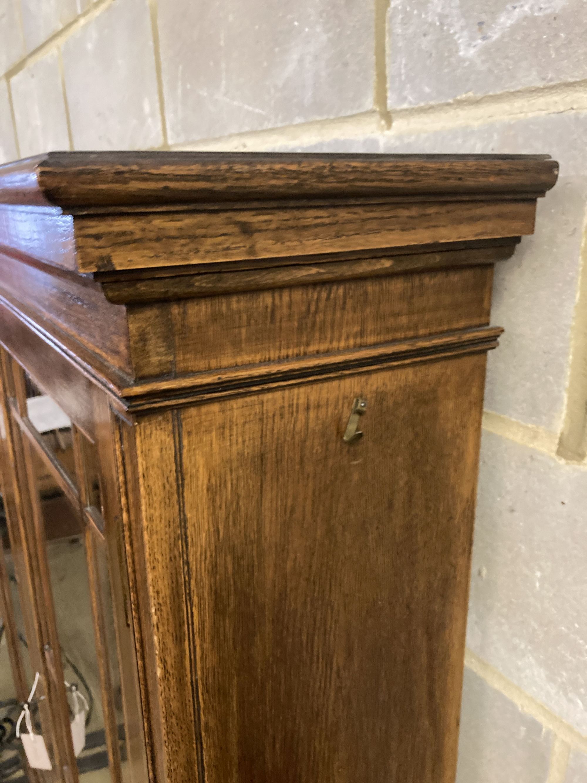 A 1920s glazed oak two door bookcase, length 130cm, depth 29cm, height 156cm